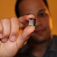 a man holding a small electronic chip