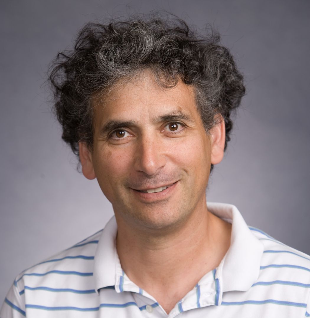 A photograph of Ethan Bier. He has dark hair and is wearing a white collared shirt with thin blue stripes.