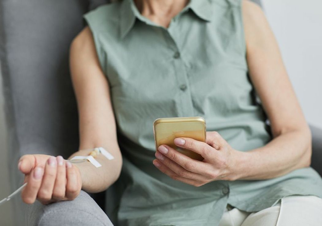 A woman receives immunotherapy through an intravenous line in her right arm.