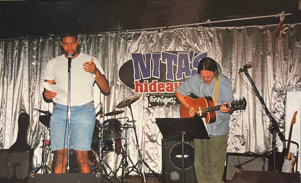 An older photo of Austin who is performing on stage with someone playing guitar in the background. An older photo of Austin who is performing on stage with someone playing guitar in the background.