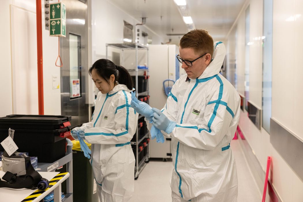 Virologist Daniel Rawle and another researcher are standing in a hallway putting on protective gear, like hazmat suits and gloves, before they go into the lab to study Japanese encephalitis virus. Virologist Daniel Rawle and another researcher are standing in a hallway putting on protective gear, like hazmat suits and gloves, before they go into the lab to study Japanese encephalitis virus.
