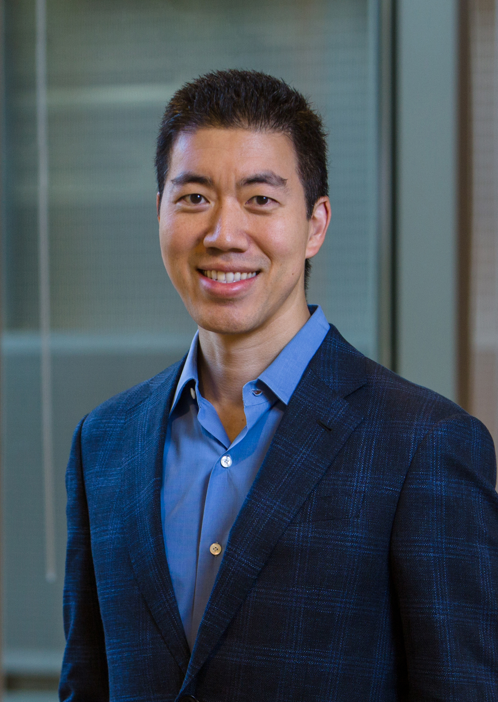 David Liu wears a dark blue suit and smiles at the camera. David Liu wears a dark blue suit and smiles at the camera.