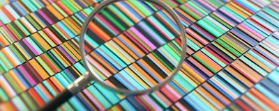 Conceptual image of DNA sequencing showing multicolored bands with a magnifying glass in the foreground. 