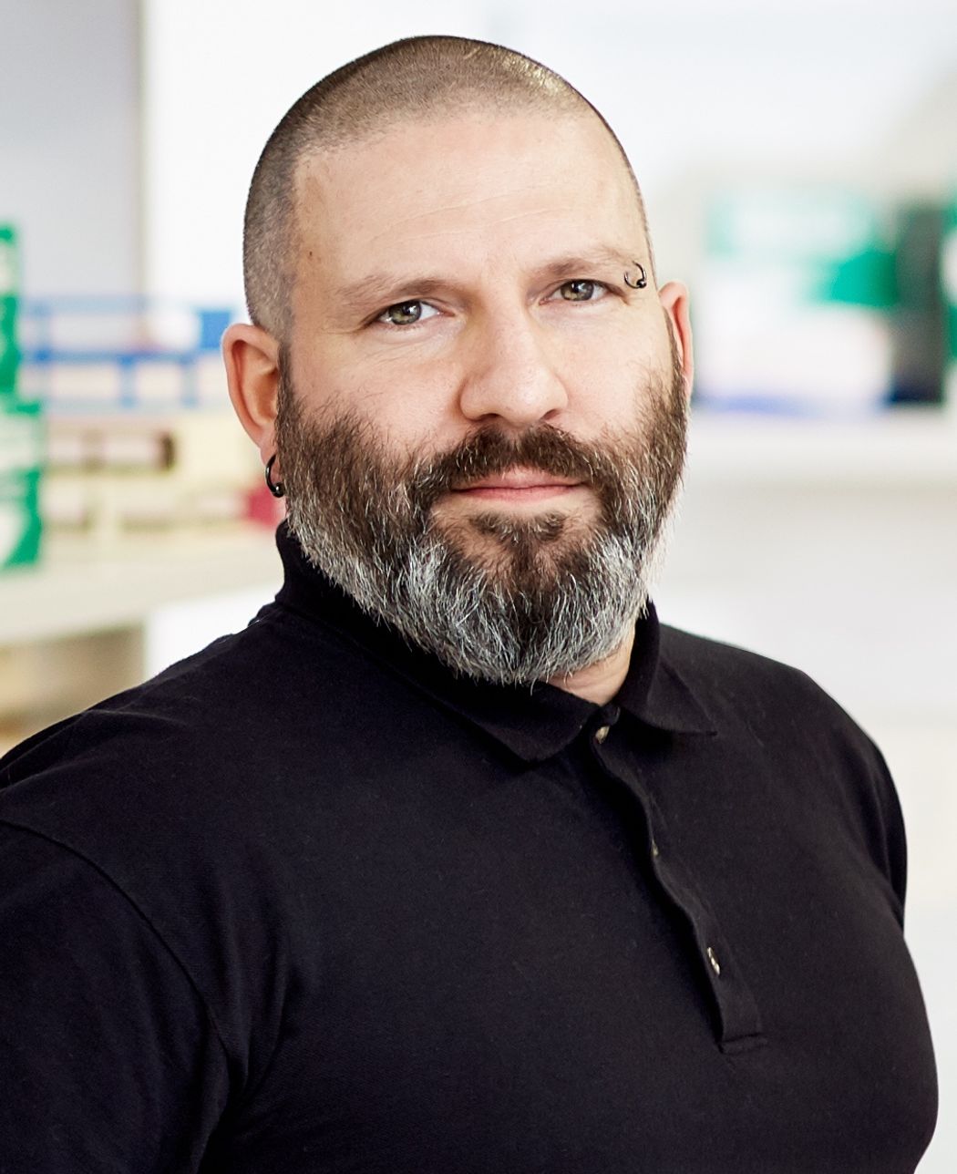 A photograph of Ludovic Desvignes, the director of high containment laboratories at New York University Langone Health. He is looking at the camera and is wearing a black collared shirt. He has a greying beard, one loop earring, and an eyebrow loop ring. A photograph of Ludovic Desvignes, the director of high containment laboratories at New York University Langone Health. He is looking at the camera and is wearing a black collared shirt. He has a greying beard, one loop earring, and an eyebrow loop ring.