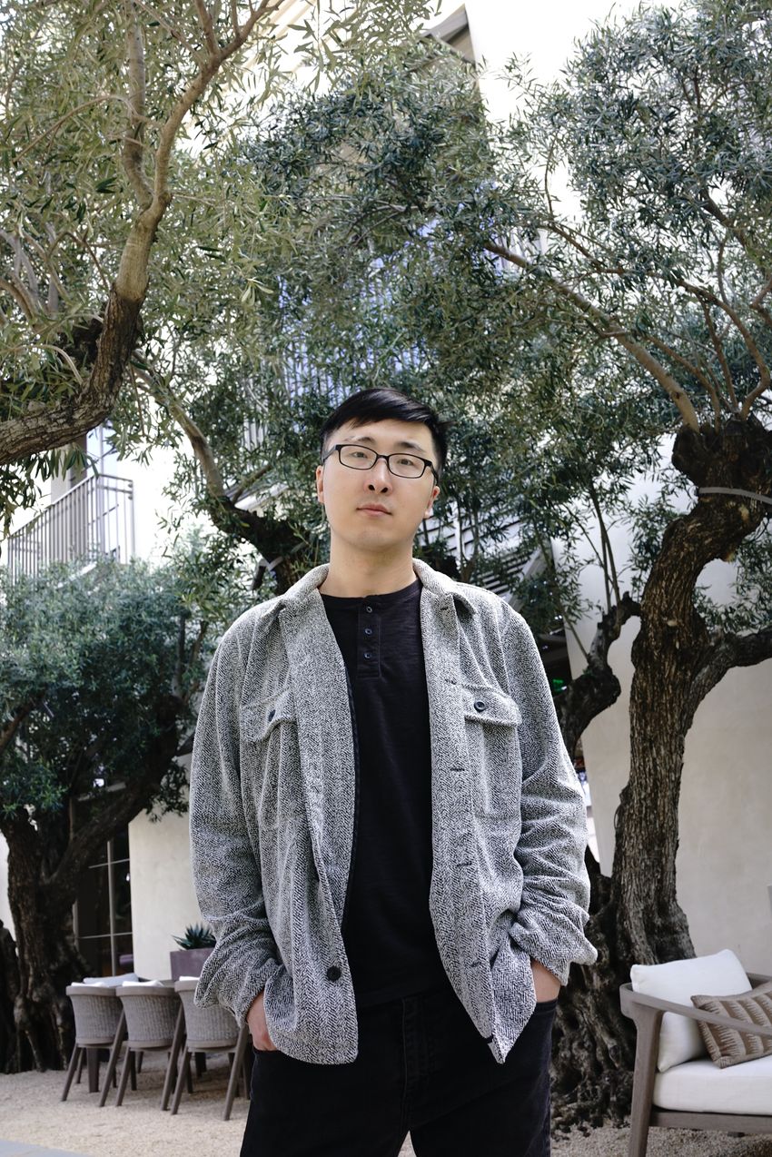 Photograph of Yanding Zhao, a postdoctoral researcher in Howard Chang’s group at Stanford University. Zhao stands in a patio with trees and chairs behind him. He has short black hair, glasses, and is wearing a grey jacket over a black shirt. Photograph of Yanding Zhao, a postdoctoral researcher in Howard Chang’s group at Stanford University. Zhao stands in a patio with trees and chairs behind him. He has short black hair, glasses, and is wearing a grey jacket over a black shirt.