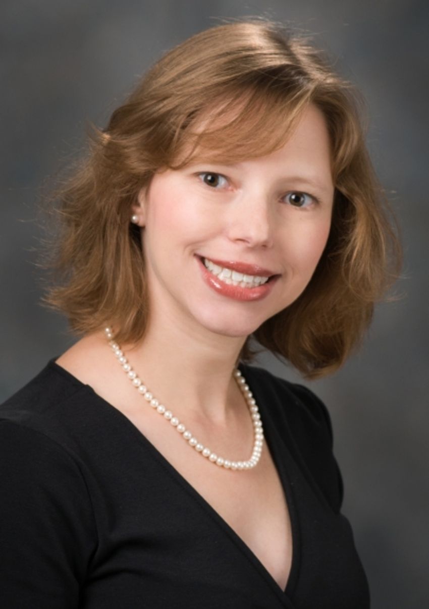 Professional photograph of Simona Shaitelman with a grey background. She has light brown, shoulder-length hair and is wearing a black top and pearl necklace. Professional photograph of Simona Shaitelman with a grey background. She has light brown, shoulder-length hair and is wearing a black top and pearl necklace.
