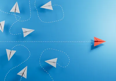 3D illustration of six paper airplanes flying in swirls, depicted by white dashed lines, on the left, and one red airplane flying straight across to the right on a blue background, used here as an indicator for leadership in academia. 3D illustration of six paper airplanes flying in swirls, depicted by white dashed lines, on the left, and one red airplane flying straight across to the right on a blue background, used here as an indicator for leadership in academia.