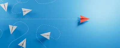 3D illustration of six paper airplanes flying in swirls, depicted by white dashed lines, on the left, and one red airplane flying straight across to the right on a blue background, used here as an indicator for leadership in academia. 