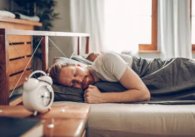 Image of a man sleeping in bed.