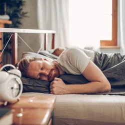 Image of a man sleeping in bed.