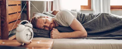 Image of a man sleeping in bed.