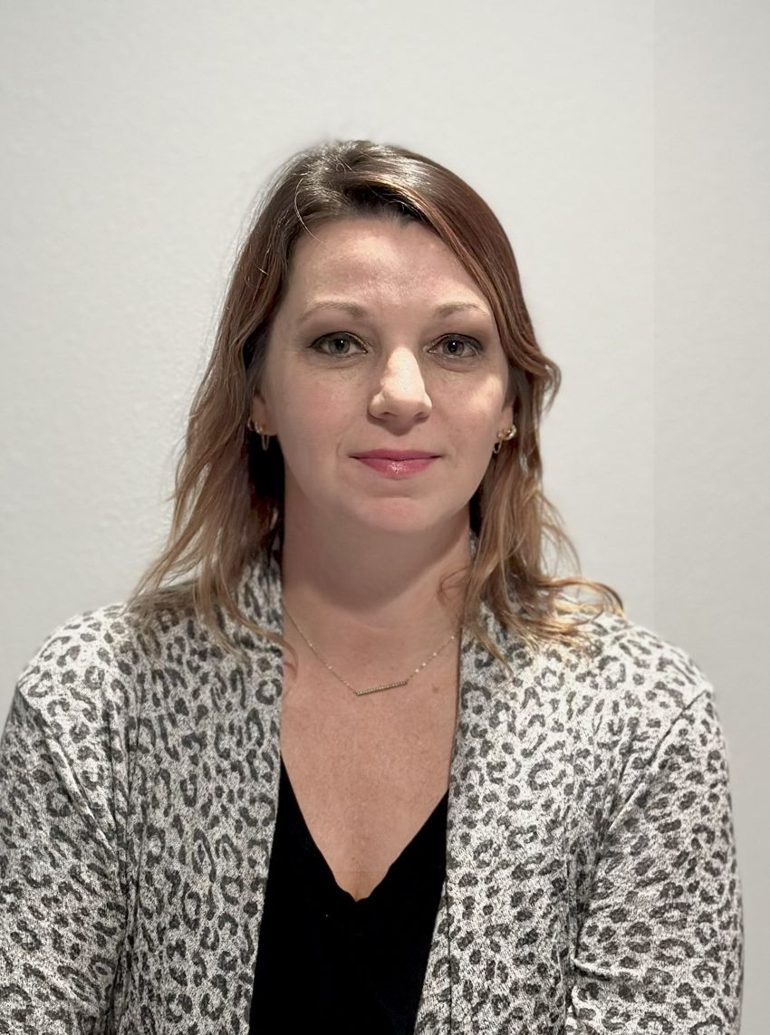 A photograph of Meghan Koch, an immunologist who studies maternal-offspring immunity, wearing a back top and grey leopard-print jacket against a plain background.