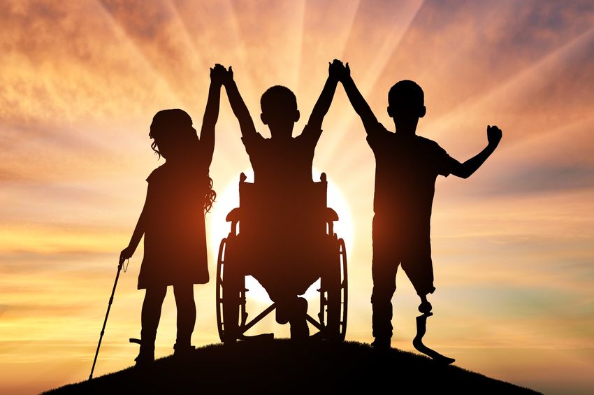 Silhouette of children with disabilities (right: long-haired child in a dress, holding a stick; middle: short-haired/hairless child in a wheelchair; right: short-haired/hairless child with a left prosthetic leg). The children are holding hands with their arms raised in front of a rising sun, illustrating the hopeful tone brought by the recent prime editing breakthrough.