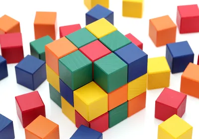 A photo of colorful cube-shaped wooden blocks stacked into a cube.