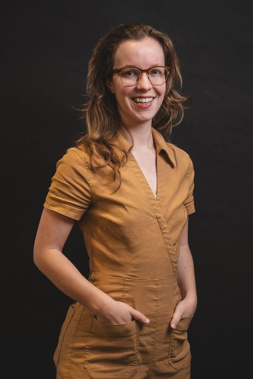 Erika DeBenedictis, wearing a camel-colored suit, smiles at the camera.