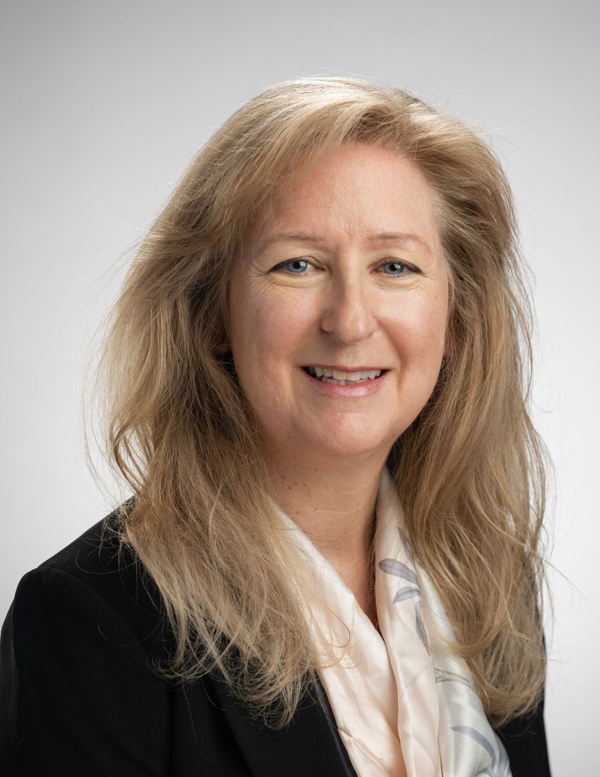 A photograph of Frances Donovan, wearing a beige top and black coat.