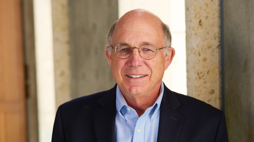 A photo of Peter Schultz wearing a black blazer and blue shirt.
