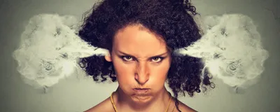 A closeup picture of an angry woman, with steam blowing out of her ears. She wears a yellow top and growls at the camera. A closeup picture of an angry woman, with steam blowing out of her ears. She wears a yellow top and growls at the camera.