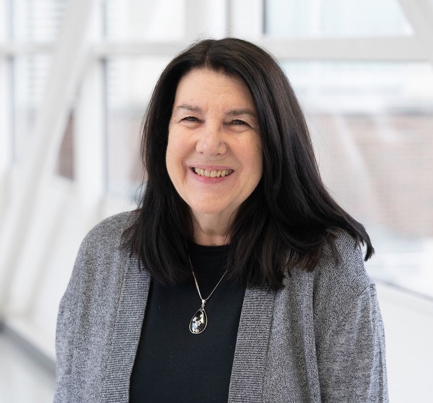 Photograph of Sharon Evans, an immunologist at Roswell Park Comprehensive Cancer Center. She has shoulder length dark hair and is wearing a grey cardigan over a black shirt with a necklace.