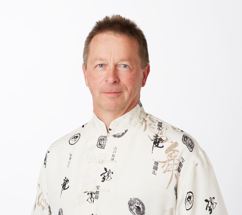 Louis Ptáček, who studies the genetics of familial advanced sleep phase trait, wears a beige shirt and smiles against a white background.