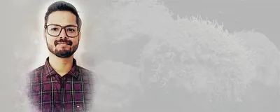 Dhruvam Pandey, a postdoctoral researcher at The College of Optics and Photonics, wears a plaid shirt and smiles gently at the camera.