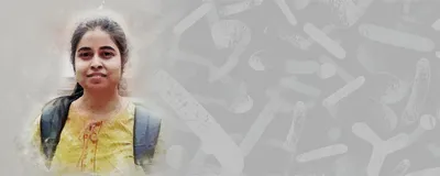 Neetu Yadav, a postdoc at Michigan State University, wears a yellow top and stands on a grass lawn.