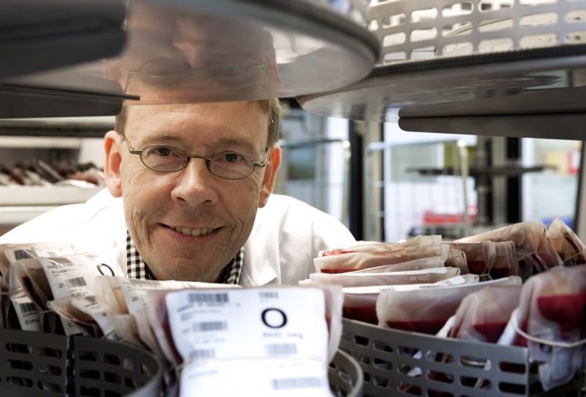Martin Olsson, who studies the biology of rare blood groups, smiles at the camera while posing with a few blood transfusion bags.