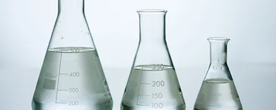 A photo of three water-filled flasks arranged by size. A photo of three water-filled flasks arranged by size.