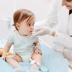 A health care professional assessing a baby, highlighting the importance of addressing early childhood health. A health care professional assessing a baby, highlighting the importance of addressing early childhood health.