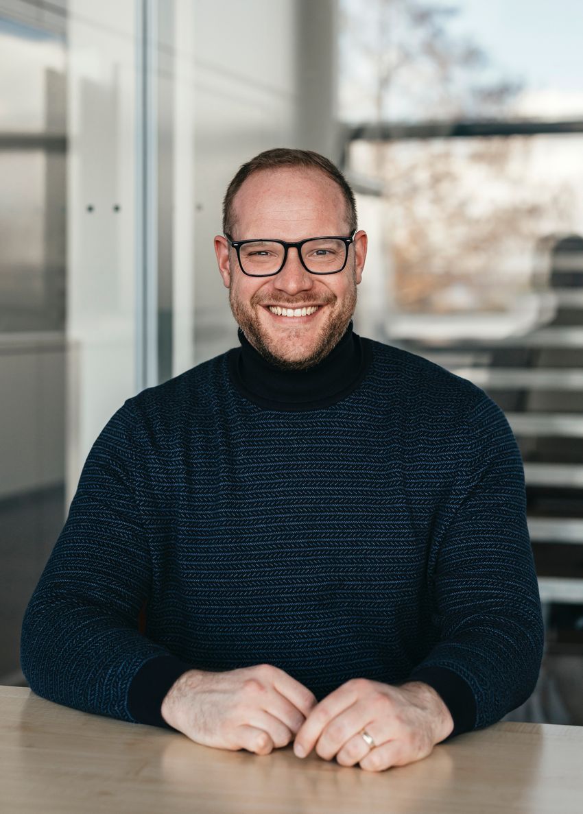 Neuroscientist Manuel Spitschan, who studies ACHOO syndrome, wears a black sweater and smiles at the camera.