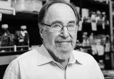 A picture of David Baltimore, a renowned molecular biologist and Nobel Laureate. 