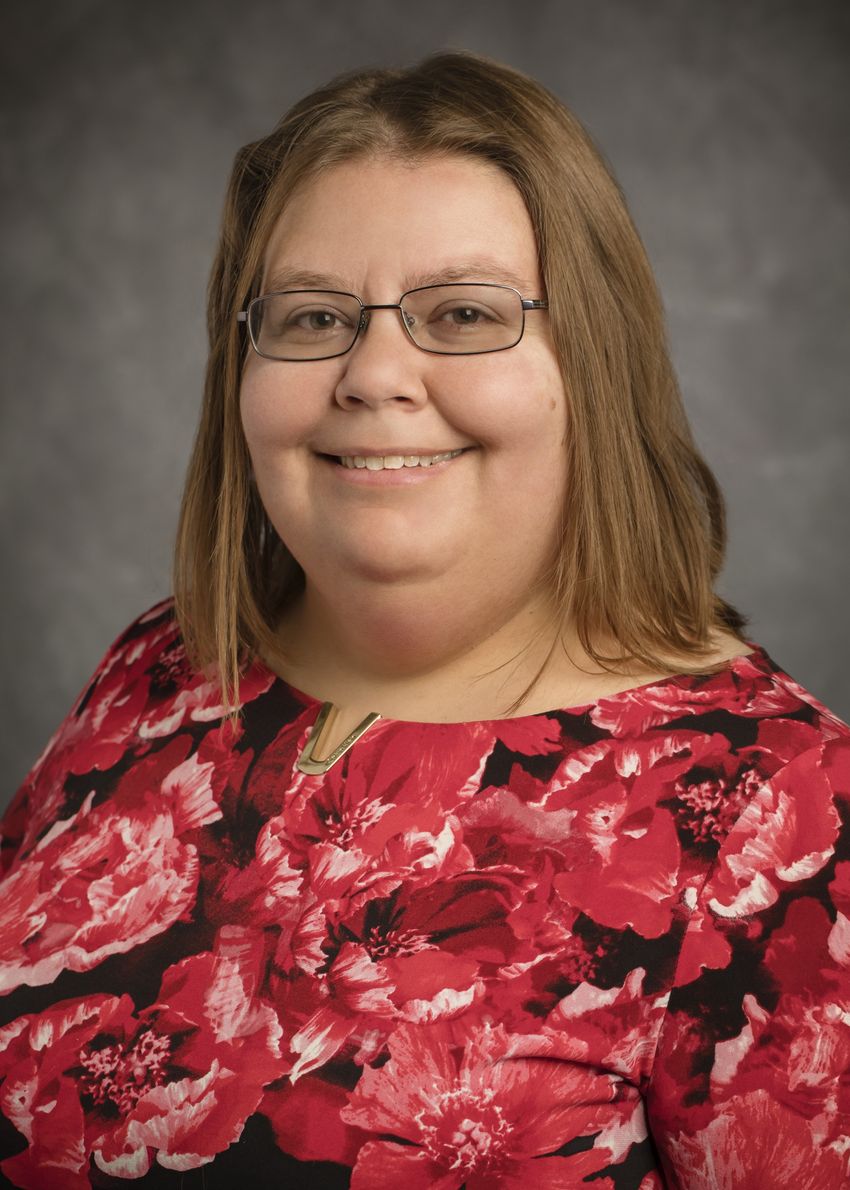 A photograph of Jodi Schneider, who studies post-citation retractions, wearing a red top and glasses.