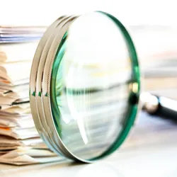 Magnifying glass in front of a stack of documents, signifying that ChatGPT ignored retractions. Magnifying glass in front of a stack of documents, signifying that ChatGPT ignored retractions.