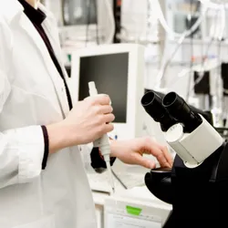 A researcher examining a sample under a confocal microscope in the laboratory. A researcher examining a sample under a confocal microscope in the laboratory.