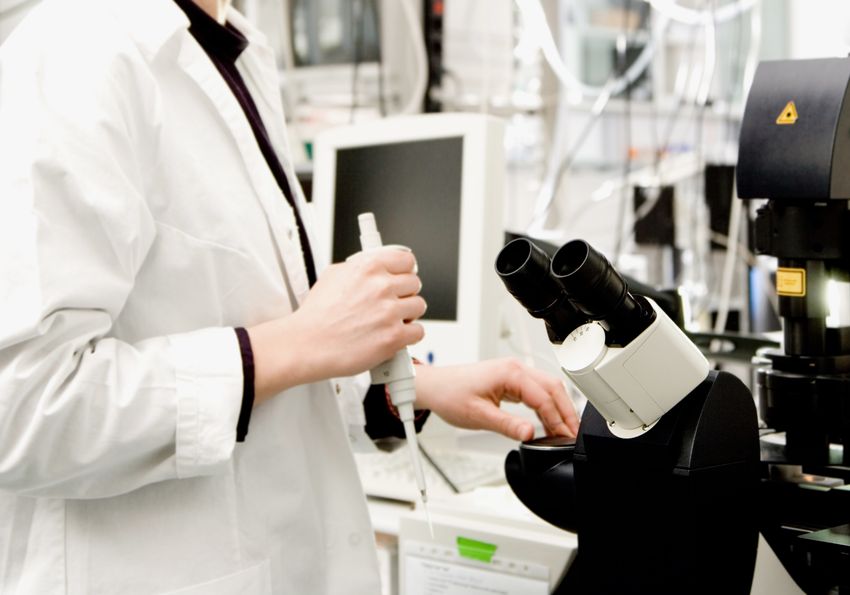 A researcher examining a sample under a confocal microscope in the laboratory.
