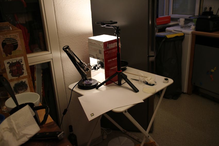 A lightbox made out of a stand and cardboard boxes sits on a table.