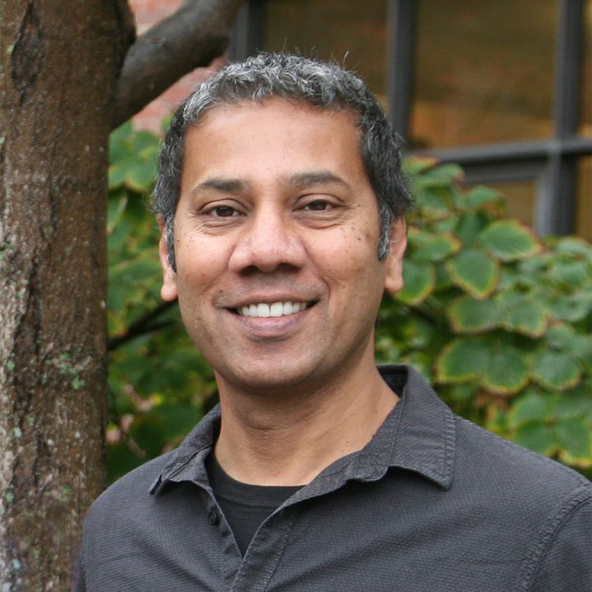 Venkatesh Murthy, wearing a black tee under a grey shirt, poses in front of a tree. Venkatesh Murthy, wearing a black tee under a grey shirt, poses in front of a tree.
