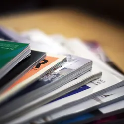Scientific journals are spread out on top of a table. Scientific journals are spread out on top of a table.