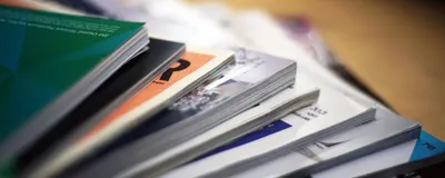 Scientific journals are spread out on top of a table.