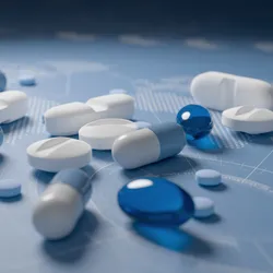 Various types of pills in blue and white lying on a blue background