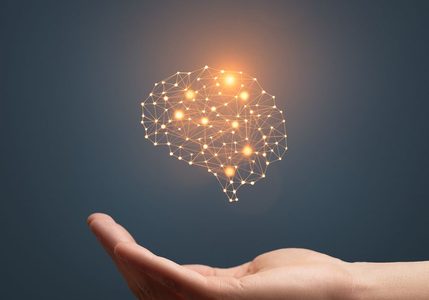 A graphic showing a hand being held out while an image of the brain, depicted in glowing and interconnected golden dots, hovers above. A graphic showing a hand being held out while an image of the brain, depicted in glowing and interconnected golden dots, hovers above.
