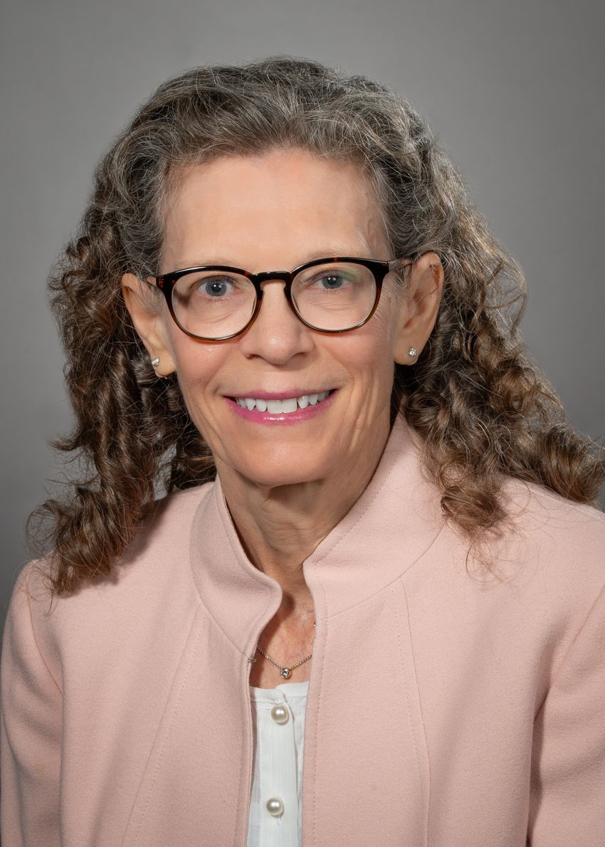 Christine Metz, a reproductive health researcher studying menstrual blood, wears a white top and pink jacket.