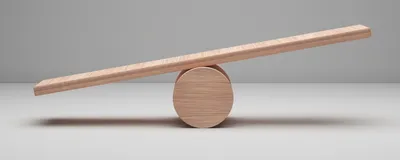 A photo of an unbalanced wooden plank resting on a round wooden ball against a neutral gray background. A photo of an unbalanced wooden plank resting on a round wooden ball against a neutral gray background.
