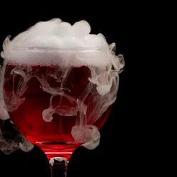 White smoke rises out of a glass of red wine, signifying the ashy taste in wines made from smoke-exposed grapes, also known as smoke taint. White smoke rises out of a glass of red wine, signifying the ashy taste in wines made from smoke-exposed grapes, also known as smoke taint.