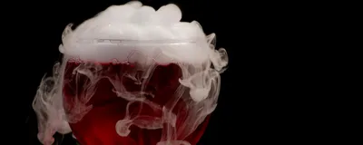 White smoke rises out of a glass of red wine, signifying the ashy taste in wines made from smoke-exposed grapes, also known as smoke taint. 