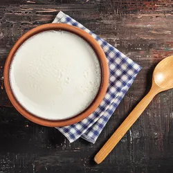 Yogurt in an earthen pot with a wooden spoon by the side. Yogurt in an earthen pot with a wooden spoon by the side.