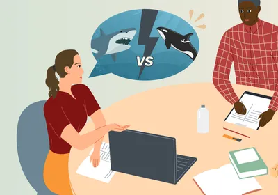 Illustration of four people seated at a table with pads of paper and laptop on it. A woman on the left of the table in a red shirt, depicting senior staff writer Emma Dauster, has a speech bubble over her head with a picture depicting a shark and orca with “vs” in between them, showing an idea for a video on battles between apex predators. 