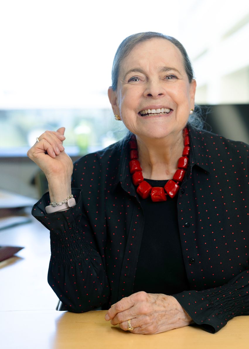 A photograph of developmental biologist Lucy Shapiro, who helped establish the field of systems biology, wearing a black top and a red necklace A photograph of developmental biologist Lucy Shapiro, who helped establish the field of systems biology, wearing a black top and a red necklace