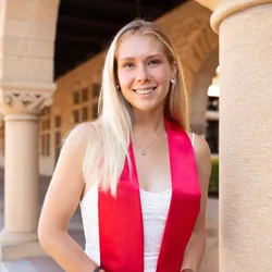 Image of Maria Shcherbakova. She had long blonde hair and wears a white top with a pink stole draped over her shoulders.