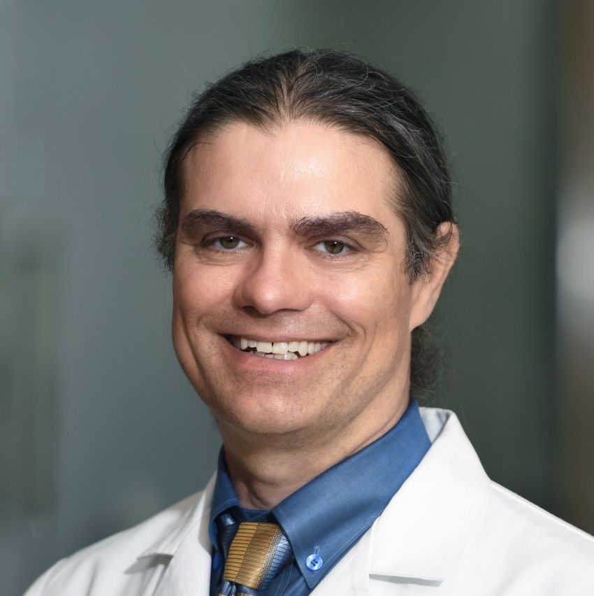 Jason Mills smiles at the camera. He’s wearing a blue shirt and yellow tie under a white labcoat. Jason Mills smiles at the camera. He’s wearing a blue shirt and yellow tie under a white labcoat.